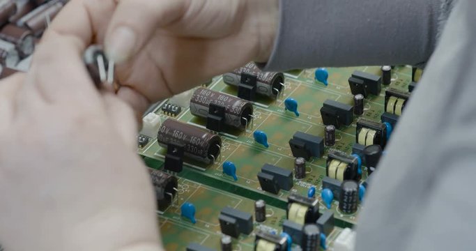 Manuall assemble parts on PCB. Closeup