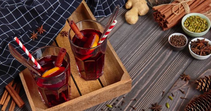 Mulled wine is poured into glasses, around are ingredients