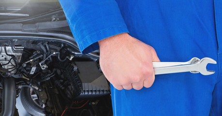 Mechanic holding wrench in garage