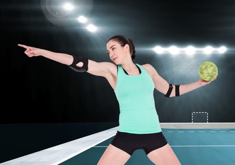 Athlete playing handball against stadium in background