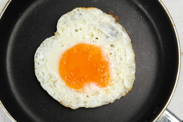 fried egg heart-shaped for breakfast on plate