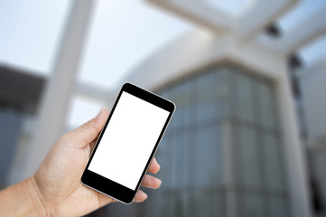 Hand holding black mobile phone with blank white screen, Blurred image for background, Concept of using a telephone in business.