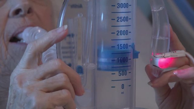Patient using an incentive spirometer or volume exerciser