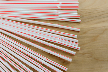 Pile of flexible drinking straws with red stripe