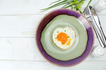 fried egg heart-shaped for breakfast on plate