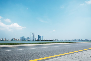 empty road and cityscape of modern city in blue sky