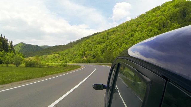 Driving on the highway in the mountains. Reflections on the car body.
