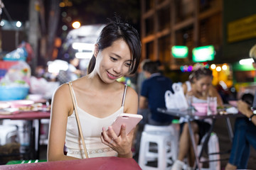 Woman use of mobile phone in night market