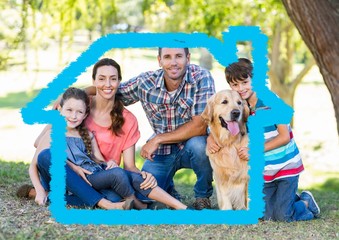 Family with dog sitting in the park with home outline