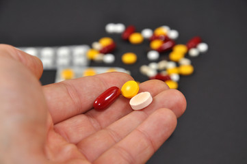 Men holding pills in his hand, few pills in men hand. Men drink pills