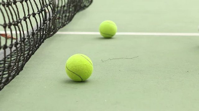 Sport Of Player Touch Rolling Tennis Ball On Ground At Green Tennis Court With Racket