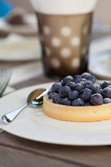 Blueberry tarte with coffee in a cafe