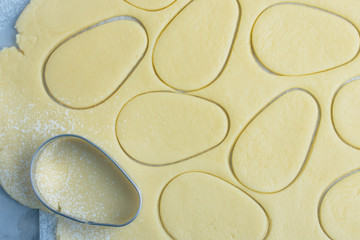 Baking egg easter cookies for Easter Holiday. Top view, horizontal image. Raw dough