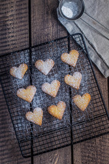 Cookies in shape of heart love for Valentines Day Holiday on Grate for cooling on wooden table. Top view