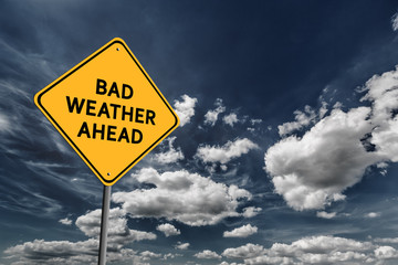 Dark blue cloudy sky and yellow road sign