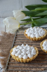 Fototapeta na wymiar Tartlets with merengue on a stand with lemon jam, still life. romantic morning