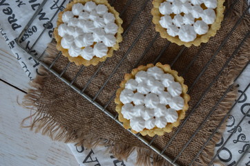 Fototapeta na wymiar Tartlets with merengue on a stand with lemon jam, still life. romantic morning