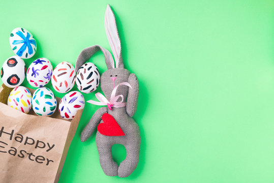 Easter eggs in a paper bag. Green background. Easter ideas. Easter eggs. Space for text. Black lettering on a bag happy easter.