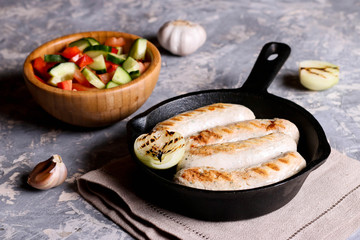 Sausages in rustic pan with onion. Frying pan with fried sausage and vegetables