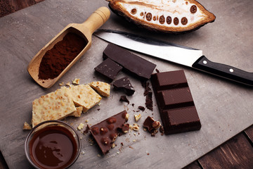 Melting chocolate and diffrent bars - stack and chips with chocolate swirl/ powder and cocoa pod with melted chocolate
