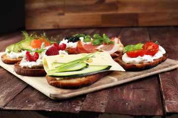 Bread Brushetta or authentic traditional spanish tapas set for lunch table. Sharing antipasti on party or summer picnic time over wooden rustic background.