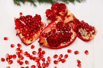 A pomegranate and grain on a white wooden background