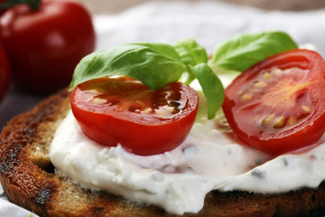 Bread with cream cheese and tomato for lunch table. Sharing antipasti on party or summer picnic time over wooden rustic background.