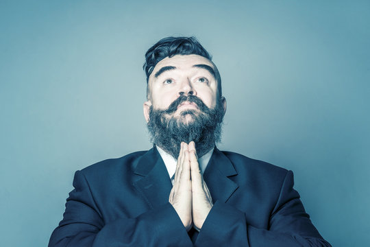 Imploring adult bearded man in a suit