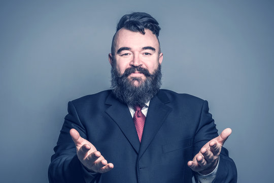 Adult bearded man in a suit stretching hands forward