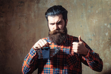 Frown bearded man holding set of wrenches with thumbs up