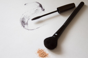 Makeup brush and mascara on white background