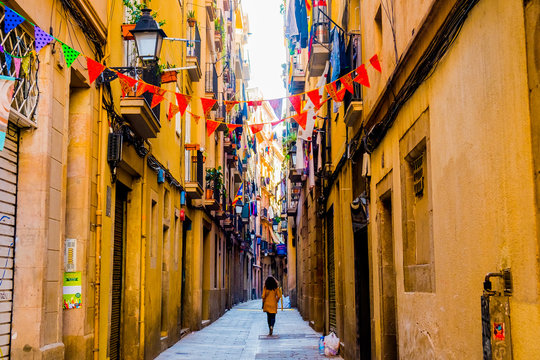 Fototapeta woman walks in old street in old center of barcelona in spring day
