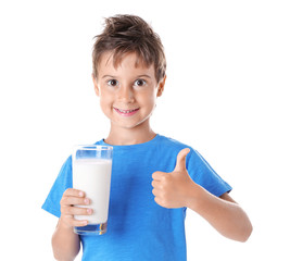 Cute boy in blue shirt holding glass of milk on white background