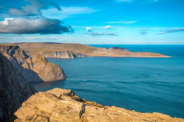 View of the fjord. Rocky sea shore with blue cloudy sky. Beautiful nature Norway. Arctic bay. Mageroya island. Nordkapp. Arctic ocean.