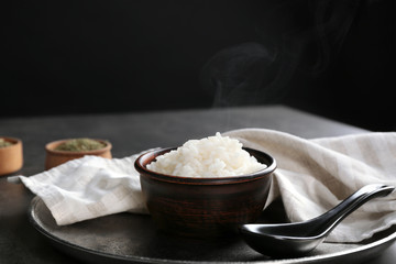White rice in bowl with spoon on tray