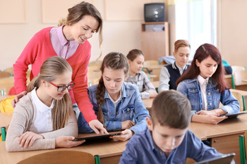 Pupils and teacher in classroom working with tablet computer