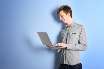 Teenager with laptop on light color background