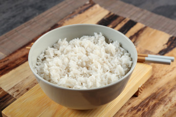 Bowl of rice and chopsticks on wooden table