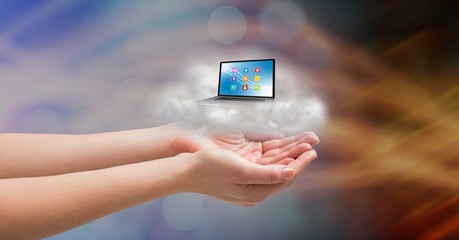 Conceptual image of cupped hands with cloud and laptop