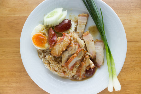 Barbecued red pork in sauce with rice on wood table background