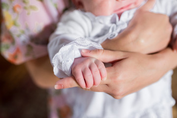 Little hand in mother hands, newborn tiny fingers, neonatal care, little stranger