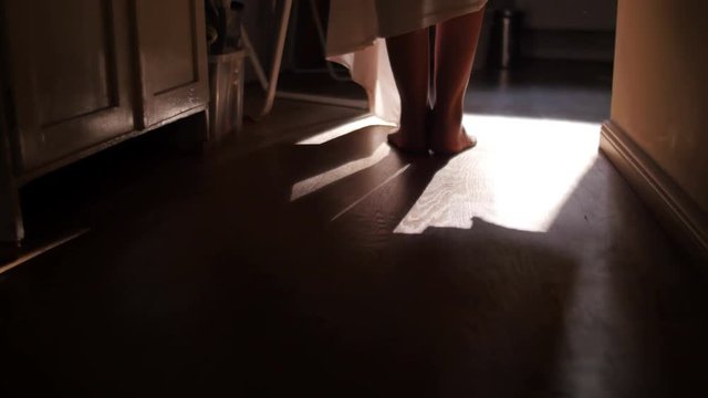Young woman leaving blanket on the floor with naked legs