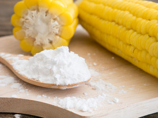 Corn flour in spoon on wooden.