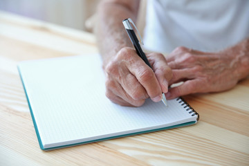 Male hands writing in copybook, closeup