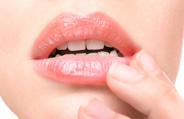 Woman with cold sore touching lips, closeup