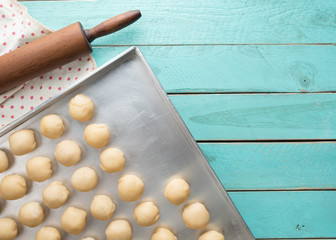 Dough and wooden rolling pin on blue wooden table
