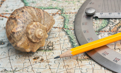 protractor and seashell on the map