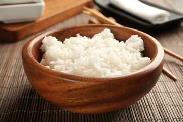 Bowl of rice and chopsticks on bamboo mat