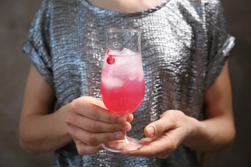 Woman holding glass of delicious wine spritzer