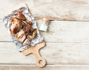 grilled chicken pieces on wooden board